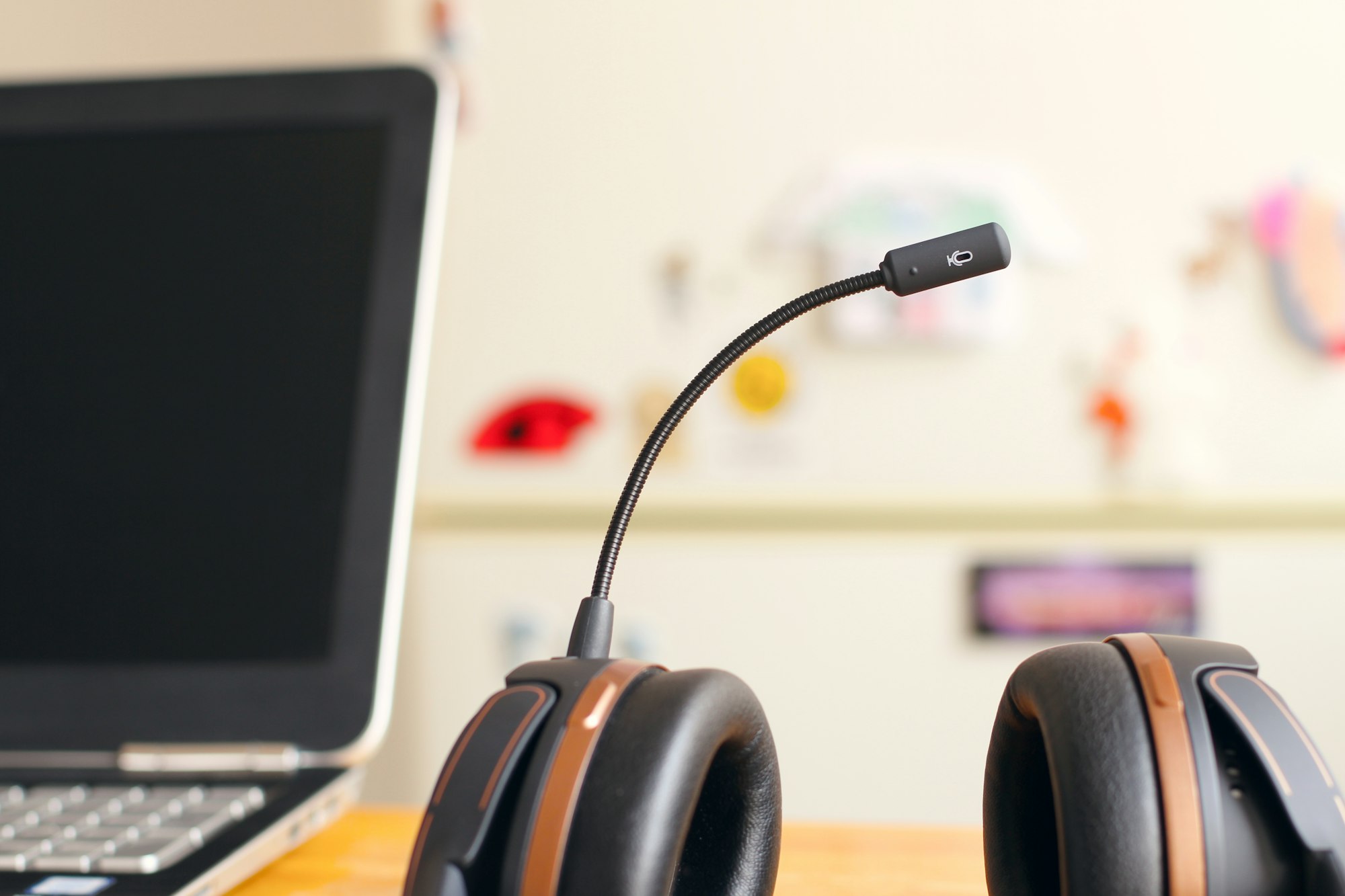 Headset naast een laptop op een bureau in warm licht